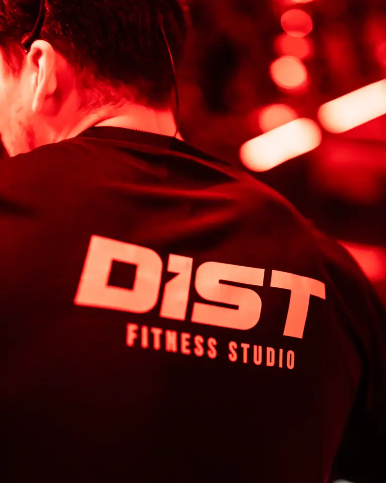 Espalda de un coach con playera DIST Fitness Studio