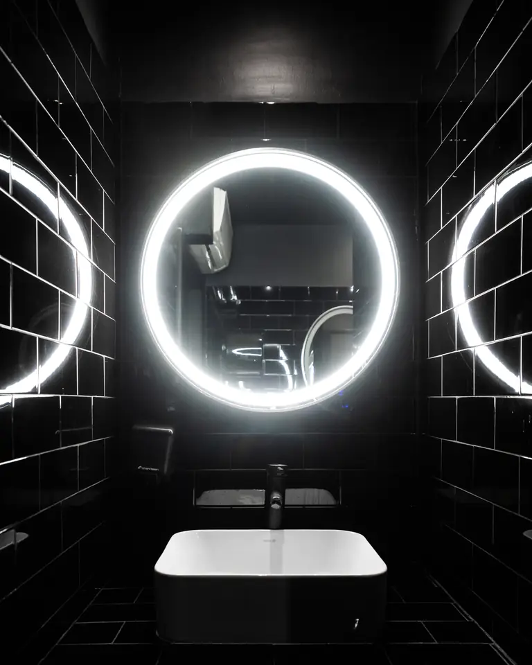 Lavabo con espejo circular iluminado en los vestidores